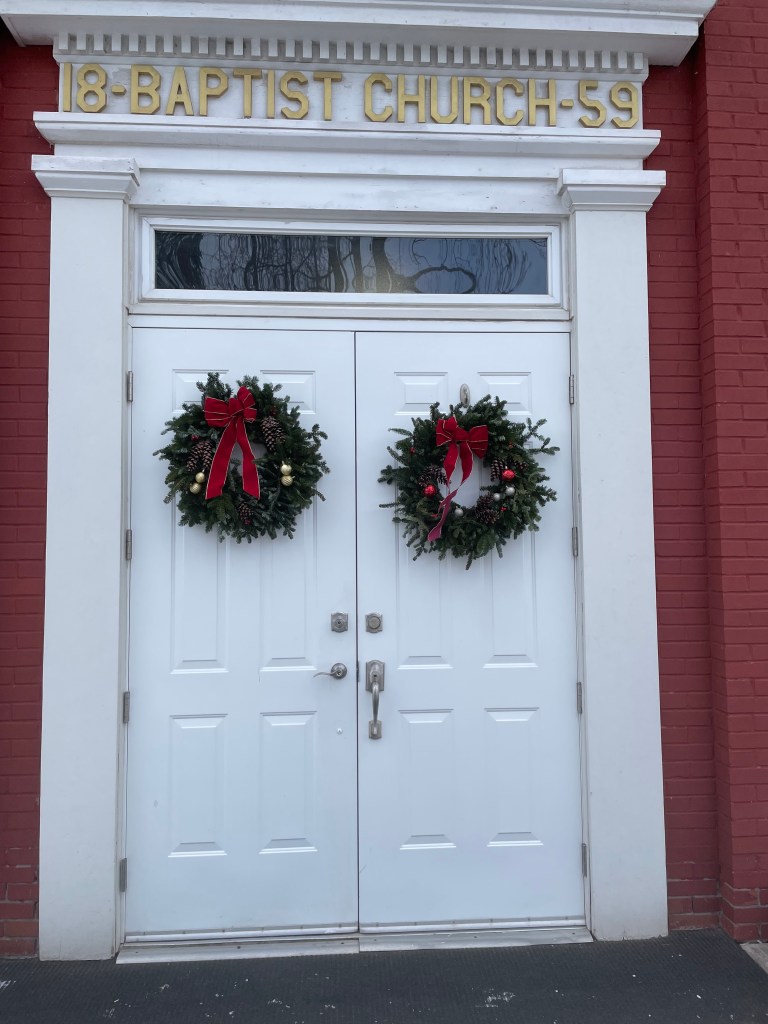 White Hall Baptist Church doors decorated with Christmas wreaths December 2025.